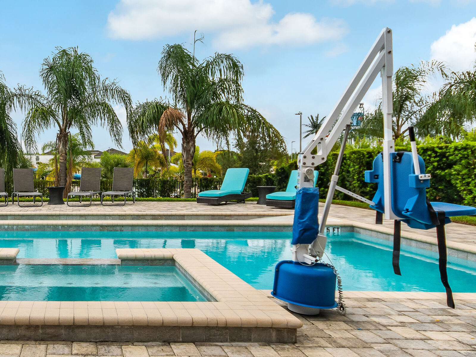 Close-up of the battery-operated pool lift chair beside the spa
